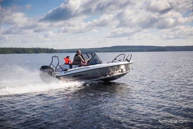 A speedboat named "FALCON" skims across a lake, with two people onboard enjoying a sunny day on the water.
